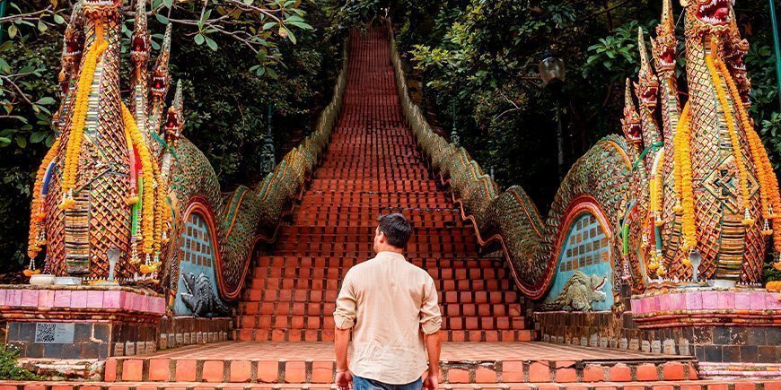 Mann går opp trappene ved Doi Suethep i Chiang Mai