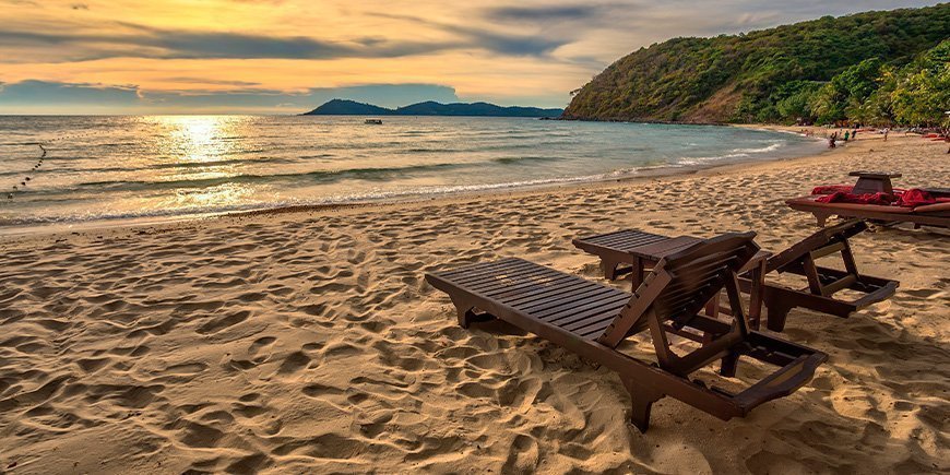 Solnedgang og solsenger på Ao Prao Beach på Koh Samet i Thailand.