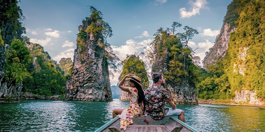 Kvinne og mann seiler på innsjøen i Khao Sok nasjonalpark i Thailand