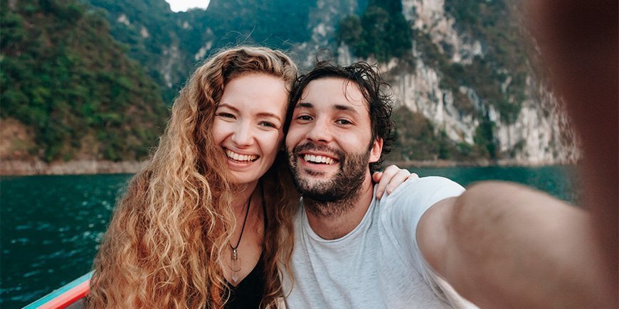 Mann og kvinne tar selfie på båt i Khao Sok nasjonalpark