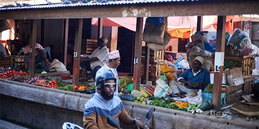 Menn selger varer på markedet i Stone Town