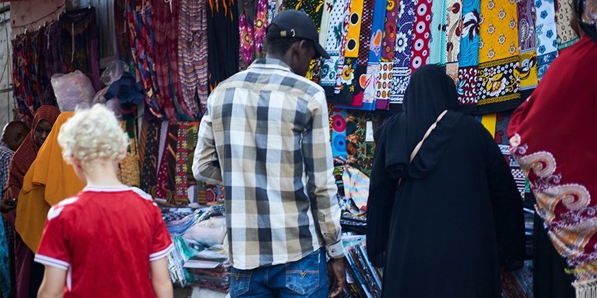 Gutt går blant lokalbefolkningen på markedet i Stone Town