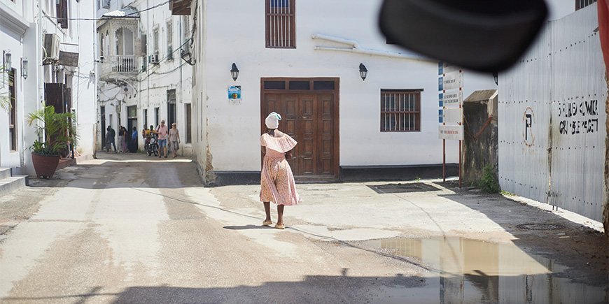 Kvinne i kjole går gjennom gatene i Stone Town