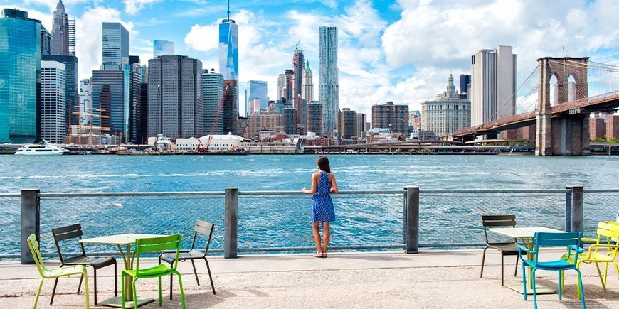 Kvinner i sommerkjoler ser på New Yorks skyline